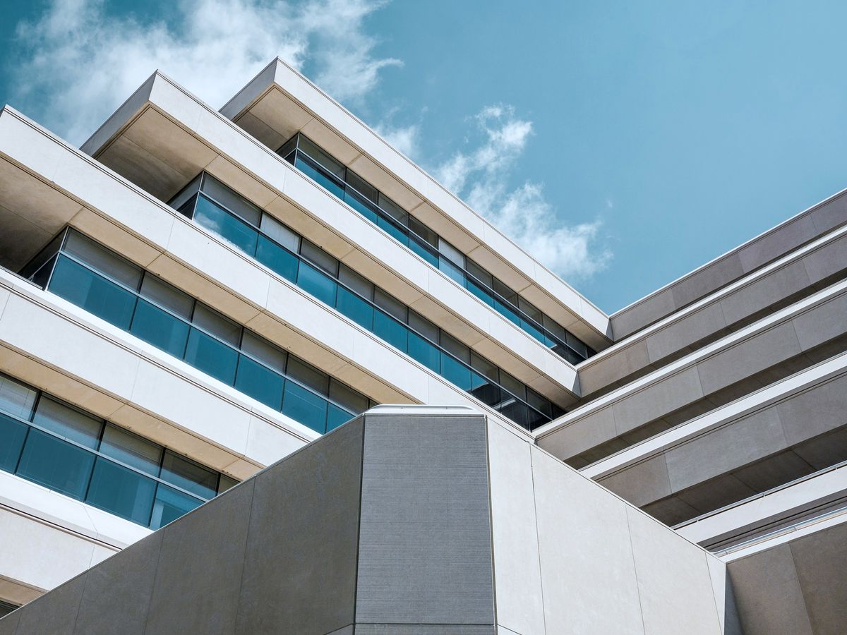 Low-angle view of a contemporary building, its stepped floors and bands of glass set against a blue sky